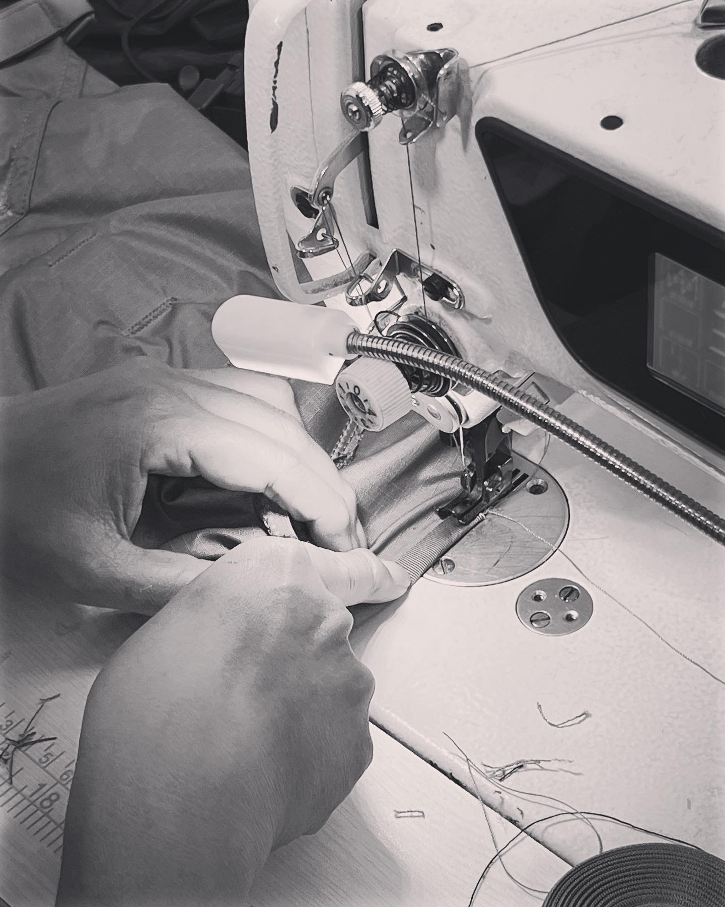 A close up of a sewer at a sewing machine at the factory where the Woolly Bully is made.